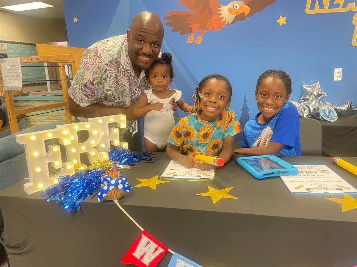Garaudy Joseph with his three children at a school welcome event